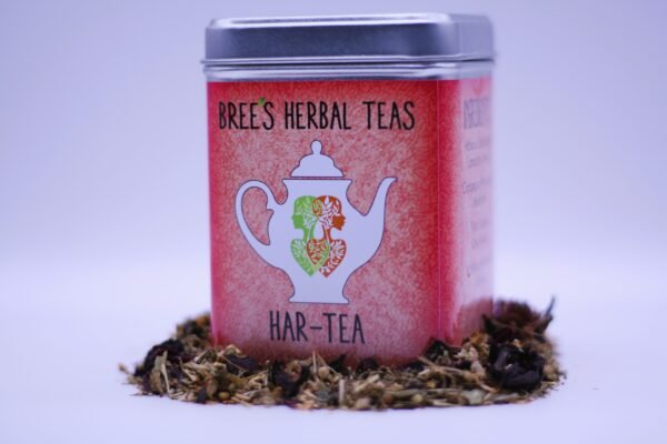 Herbal tea to promote heart health in a red tin surrounded by herbal tea with a white background