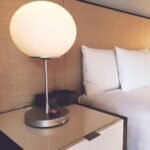 silver and white desk lamp beside bed