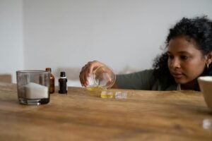 a woman pouring yellow liquid in glass container