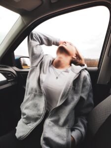 woman sitting in car leaning head back