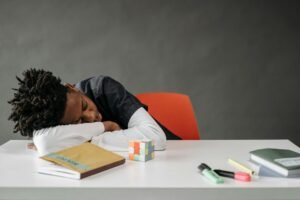 close up shot of a boy sleeping at a table